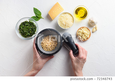 Pesto sauce cooking with woman hands and mortar . 72348743