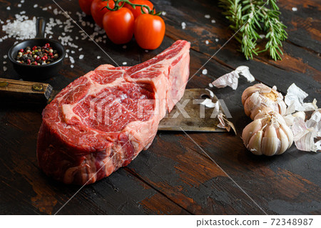 Raw Cowboy steak on dark wooden vintage table 72348987