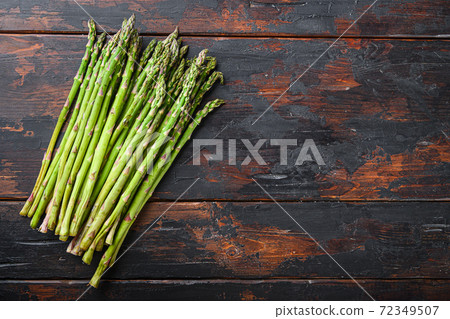 Raw organic asparagus on dark wooden old Raw organic asparagus on dark wooden old 72349507