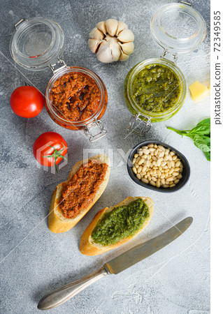 Glass jars with red and green pesto and cooking Glass jars with red and green pesto and cooking 72349585