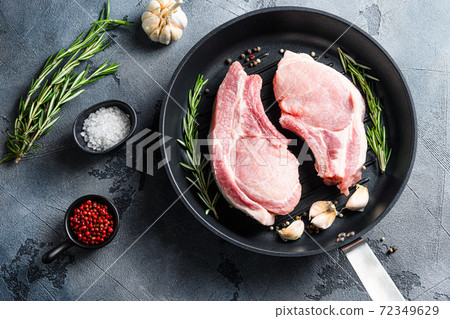 Cutlet on a rib pork in cast iron pan top view Cutlet on a rib pork in cast iron pan top view 72349629