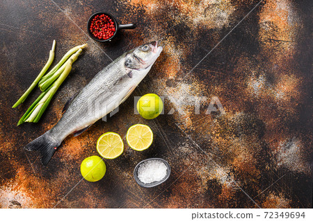 Raw seabass with spices and herbs ingredients over 72349694