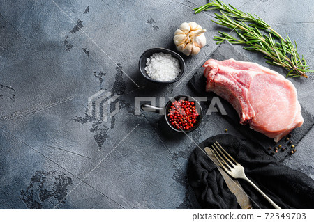 Pork chopes with herbs, spices on black slate over Pork chopes with herbs, spices on black slate over 72349703