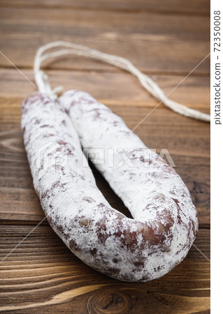 White fermented fuet sausage on light wooden 72350008