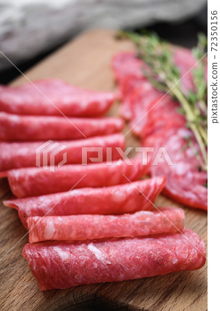 Salchichon sausages cut in slices on dark wooden Salchichon sausages cut in slices on dark wooden 72350156