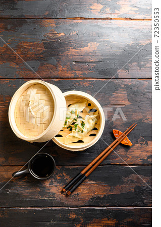 Boiled and hot chinese dumplings in wooden steamer 72350553