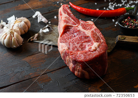 Raw dry Cowboy steak on dark wooden vintage table 72350653