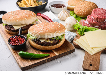 Two homemade beef burgers with components on white 72350666