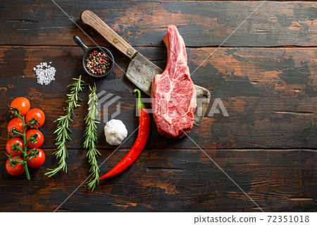 Raw Ribeye Steak, Bone-In steak on meat cleaver. 72351018