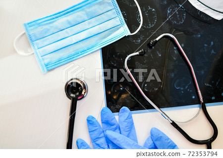 MRI in medical office. MRI scan of human head in clinic with Stethoscope. Protective mask and gloves. MRI in medical office. MRI scan of human head in clinic with Stethoscope. Protective mask and gloves. 72353794