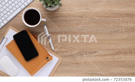 Top view wooden workspace office desk with computer and office supplies. Flat lay work table with blank notebook, keyboard, pen , smartphone and coffee cup. Copy space for your advertising content.. Top view wooden workspace office desk with computer and office supplies. Flat lay work table with blank notebook, keyboard, pen , smartphone and coffee cup. Copy space for your advertising content.. 72353876