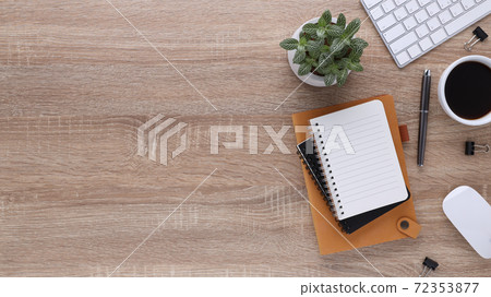 Top view wooden workspace office desk with computer and office supplies. Flat lay work table with blank notebook, keyboard, pen , smartphone and coffee cup. Copy space for your advertising content.. Top view wooden workspace office desk with computer and office supplies. Flat lay work table with blank notebook, keyboard, pen , smartphone and coffee cup. Copy space for your advertising content.. 72353877