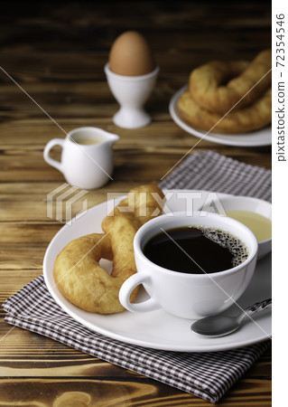 Fresh homemade Chinese donut with black coffee on vintage wooden table. Freshness breakfast with boiled egg for healthy and nutrition food with top copy space for your advertising content. Fresh homemade Chinese donut with black coffee on vintage wooden table. Freshness breakfast with boiled egg for healthy and nutrition food with top copy space for your advertising content. 72354546