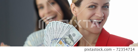 Young beautiful woman in red jacket holds cash portrait on background of partner Young beautiful woman in red jacket holds cash portrait on background of partner 72354714
