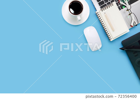 top view blue pastel office desk with computer, office supplies, cell phone, and black coffee cup top view blue pastel office desk with computer, office supplies, cell phone, and black coffee cup 72356400