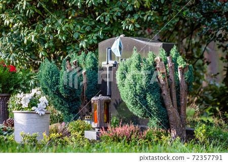 Facemask lying on grave of family members with a facemask during the pandemic 72357791