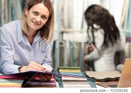 Woman designer holding ballpoint pen and clipboard curtain salon 72358100