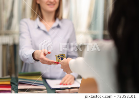 Customer handing credit bank card to sellers hand closeup 72358101