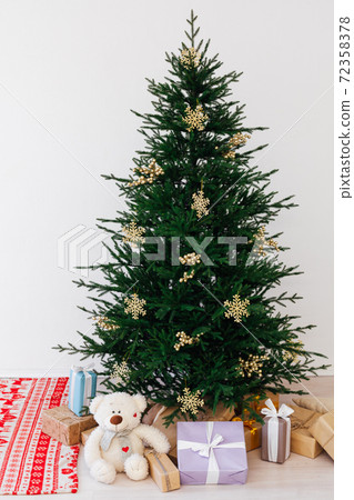 Christmas tree with new year gifts in a white room with a window 72358378