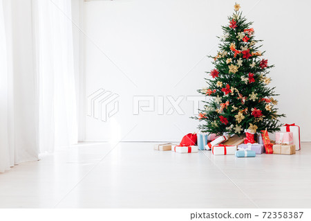 decorated Christmas tree with New Year's gifts in a room with a window decorated Christmas tree with New Year's gifts in a room with a window 72358387