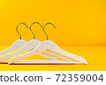White hangers on a yellow background. Sales clothes concept. 72359004