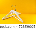 White hangers on a yellow background. Sales clothes concept. 72359005