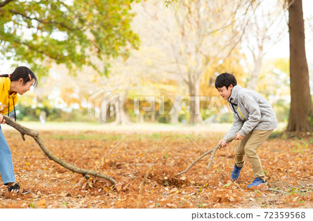 Children playing with fallen leaves Children playing with fallen leaves 72359568
