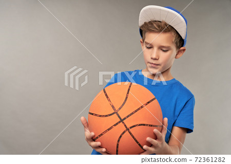 Adorable male child in cap holding basketball ball Adorable male child in cap holding basketball ball 72361282