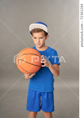 Adorable boy basketball player holding game ball Adorable boy basketball player holding game ball 72361284