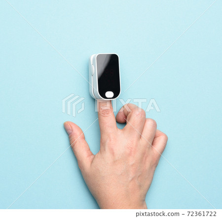 checking blood oxygen level with a portable oximeter 72361722