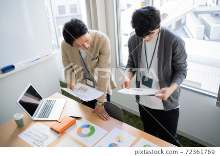 A young businessman brainstorming in a conference room 72361769