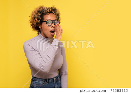 Young african american woman with hand on mouth telling secret rumor. Young african american woman with hand on mouth telling secret rumor. 72363513