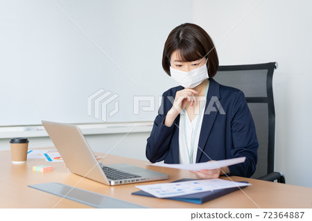 一個女人在辦公室用面具工作 72364887