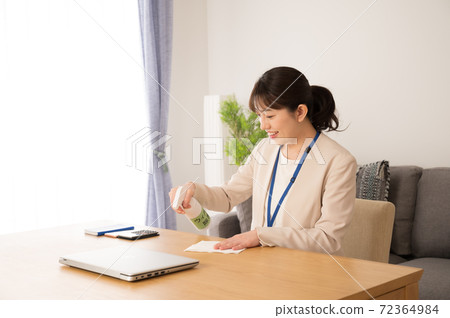 一個上班前對桌子消毒的女人 一個上班前對桌子消毒的女人 72364984