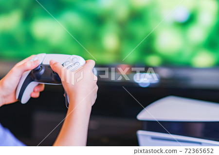 Teenager playing with a game controller [e-sports] 72365652