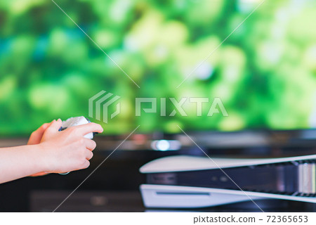 Teenager playing with a game controller [e-sports] 72365653