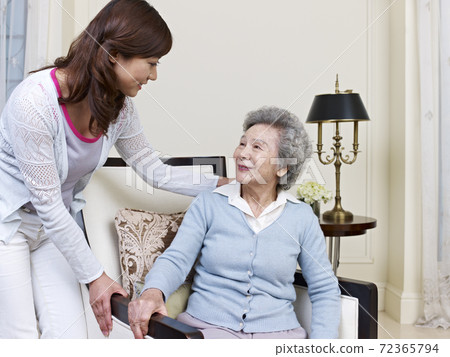 senior asian woman getting help from young adult senior asian woman getting help from young adult 72365794