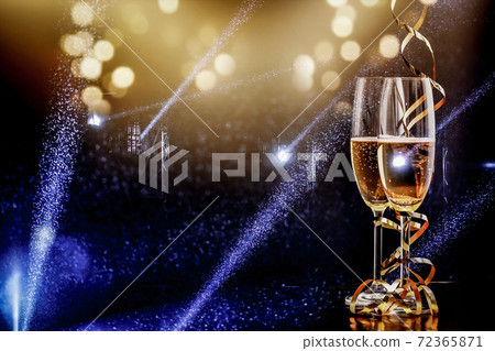 two glasses of champagne in the spotlight - new year celebration two glasses of champagne in the spotlight - new year celebration 72365871