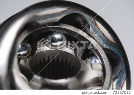 Close-up of a new CV joint on a gray background. Car suspension parts Close-up of a new CV joint on a gray background. Car suspension parts 72367021
