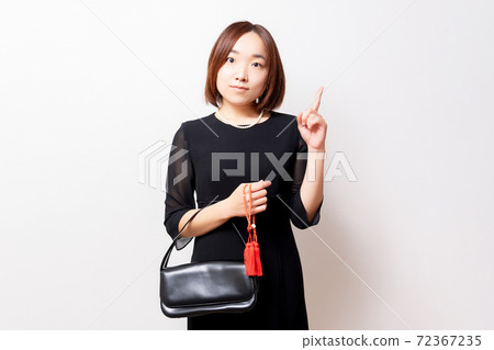一個女人穿著哀悼的衣服,指向一個點 一個女人穿著哀悼的衣服,指向一個點 72367235