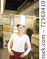 The happy bakery saleswoman is in the bakery  72369419