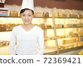 The happy bakery saleswoman is in the bakery 72369421