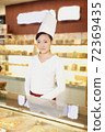 The happy bakery saleswoman is in the bakery  72369435