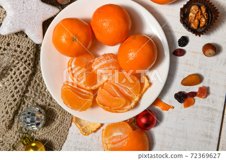 sweet food background for christmas or holiday decoration - chocolate candies, tangerines, nuts and dried fruits on white wood sweet food background for christmas or holiday decoration - chocolate candies, tangerines, nuts and dried fruits on white wood 72369627