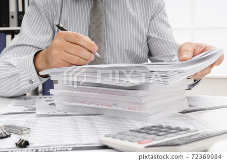 business concept - businessman's working table close view, checks financial reports, writes and counts business concept - businessman's working table close view, checks financial reports, writes and counts 72369984