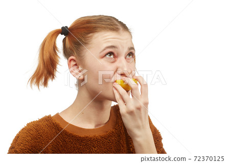 girl eats lemon 72370125