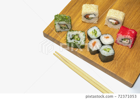 sushi and sticks on a wooden Board on a white background sushi and sticks on a wooden Board on a white background 72371053