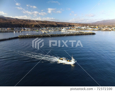 Aerial view of a fishing boat fishing from Shikabe Port, Shikabe Town, Hokkaido in early winter Aerial view of a fishing boat fishing from Shikabe Port, Shikabe Town, Hokkaido in early winter 72372100