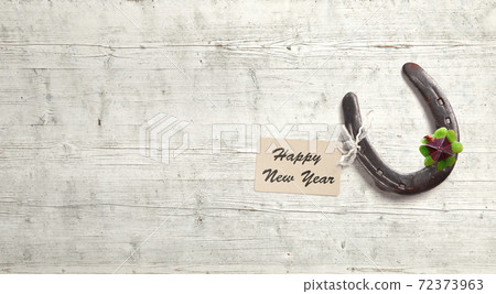 Horseshoe with lucky clover on a wooden background Horseshoe with lucky clover on a wooden background 72373963