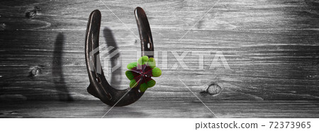 Horseshoe with lucky clover on a wooden background Horseshoe with lucky clover on a wooden background 72373965